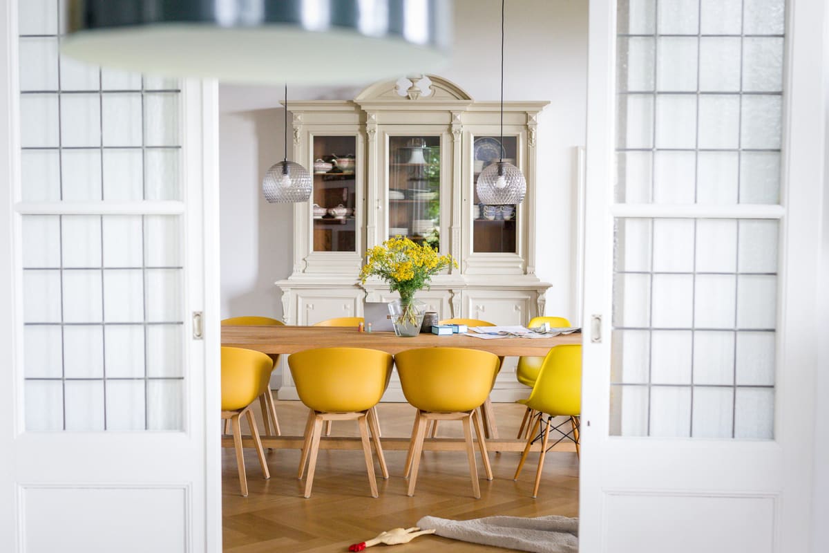 interieurontwerp-interieurstyling-eetkamer-utrecht-gele-stoelen Eetkamer met gele stoelen, houten tafel en klassieke kast voor interieurontwerp en interieurstyling